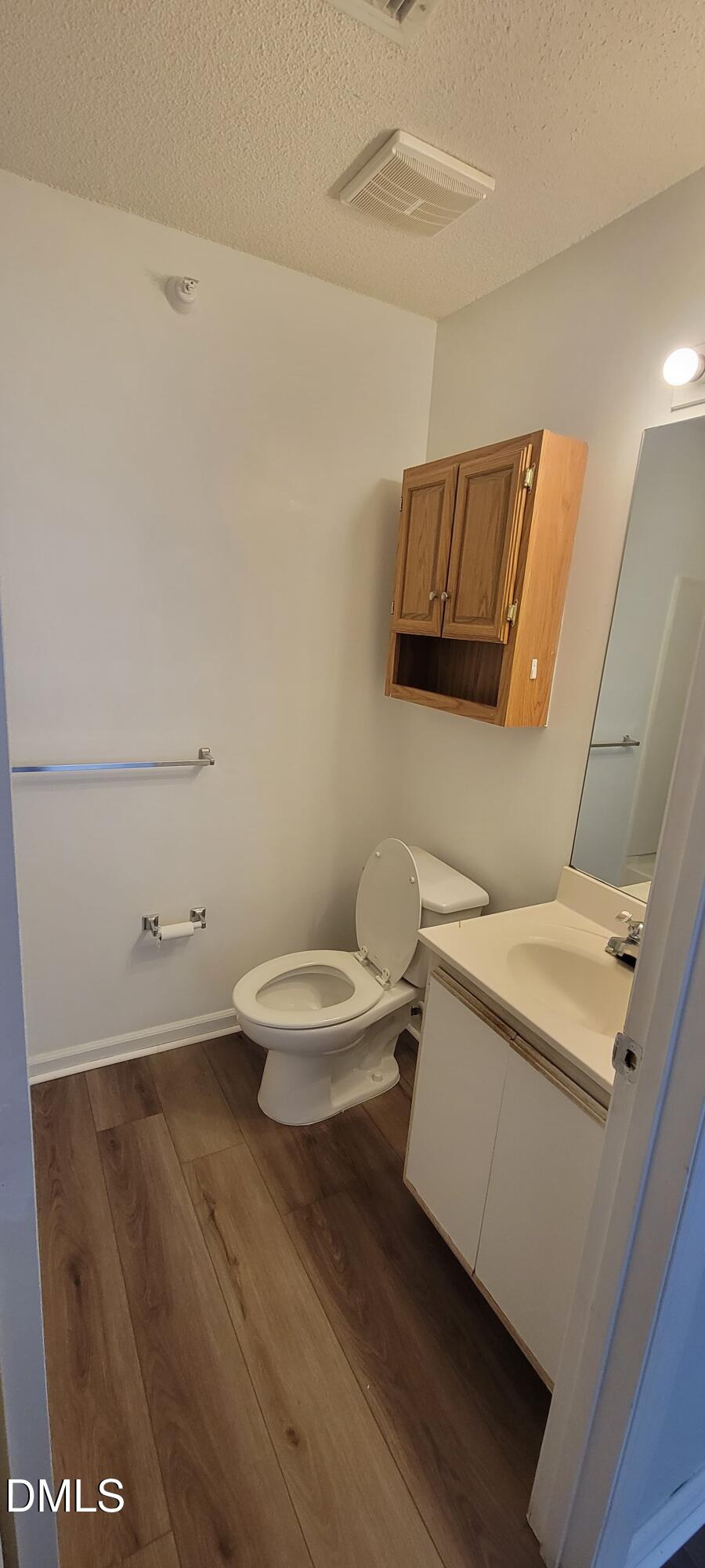 1110 Carlton Avenue, Unit 204 Raleigh, NC 27606 - Photo 8 of 12 a bathroom with a toilet a sink and mirror