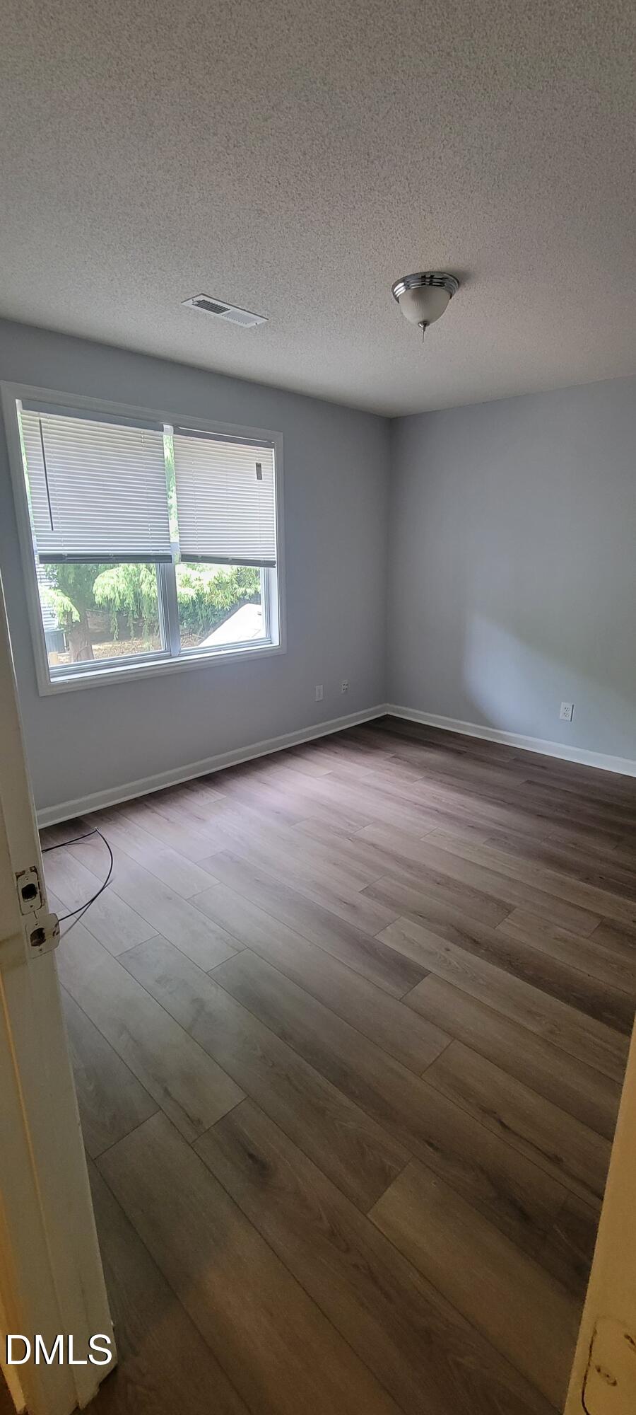 1110 Carlton Avenue, Unit 204 Raleigh, NC 27606 - Photo 9 of 12 an empty room with wooden floor and windows