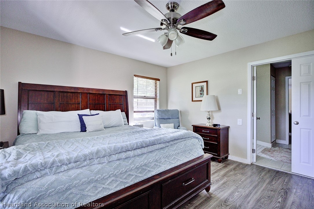 3601 Divot Road Sebring, FL 33872 - Photo 19 of 31 a bedroom with a bed and a chandelier