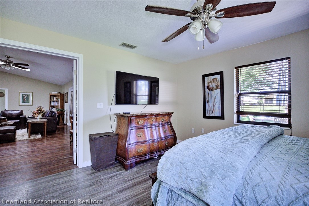 3601 Divot Road Sebring, FL 33872 - Photo 20 of 31 a bedroom with a bed and a chandelier