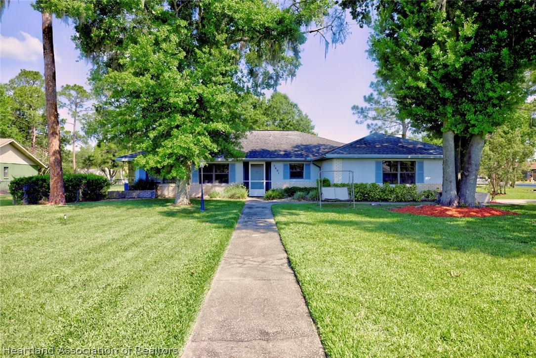 3601 Divot Road Sebring, FL 33872 - Photo 2 of 31 a front view of a house with a yard and trees