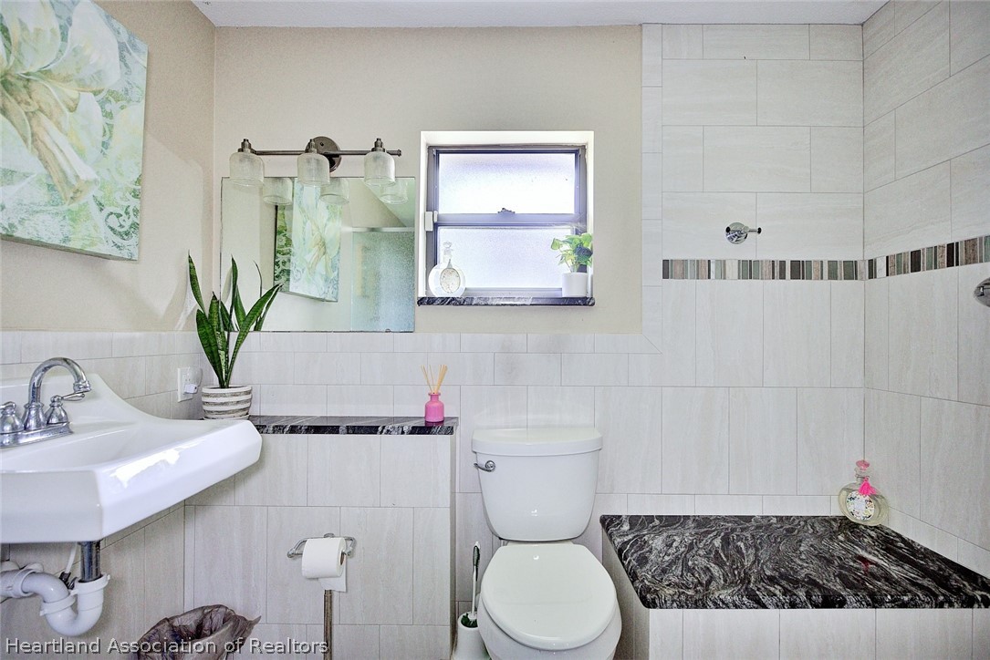 3601 Divot Road Sebring, FL 33872 - Photo 22 of 31 a bathroom with a toilet sink and mirror