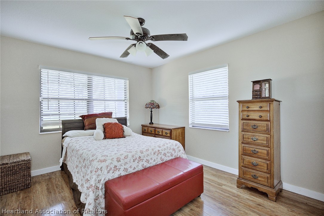 3601 Divot Road Sebring, FL 33872 - Photo 28 of 31 a bedroom with a bed and a dresser with wooden floor
