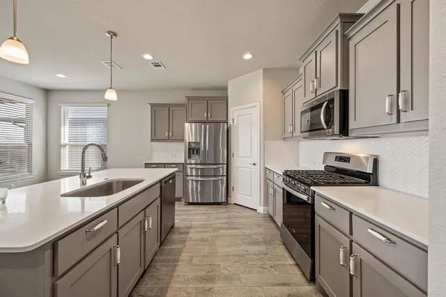 a kitchen with stainless steel appliances granite countertop a sink stove and refrigerator