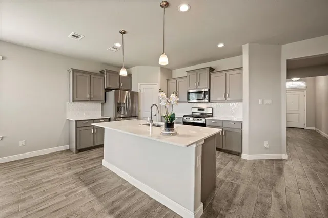 a kitchen with kitchen island a sink stainless steel appliances and cabinets