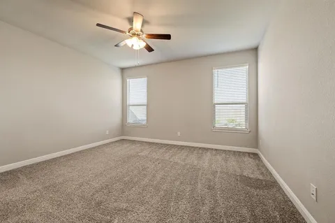 an empty room with a window and a fan
