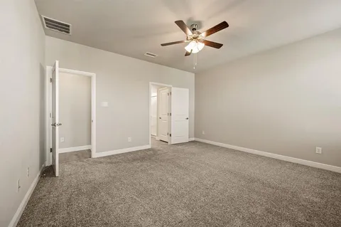 an empty room with closet and fan