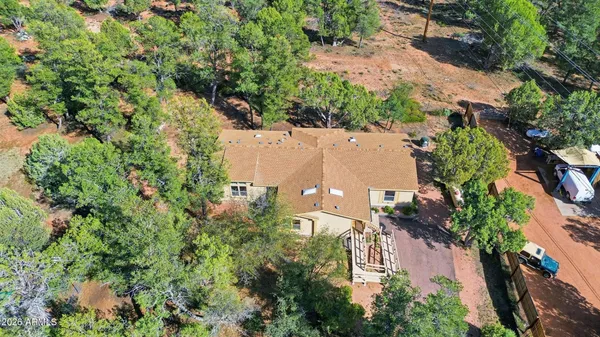 an aerial view of residential house with outdoor space and trees all around