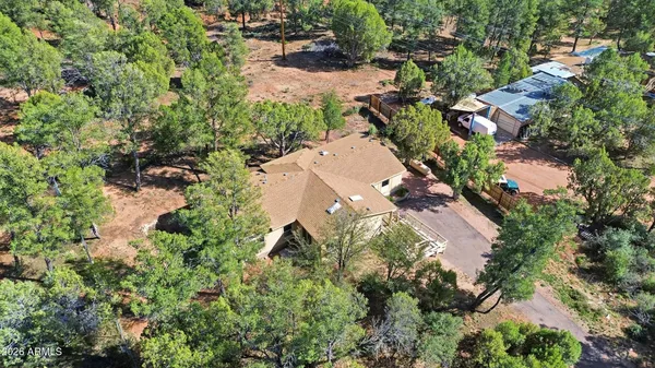 an aerial view of residential house with outdoor space and trees all around