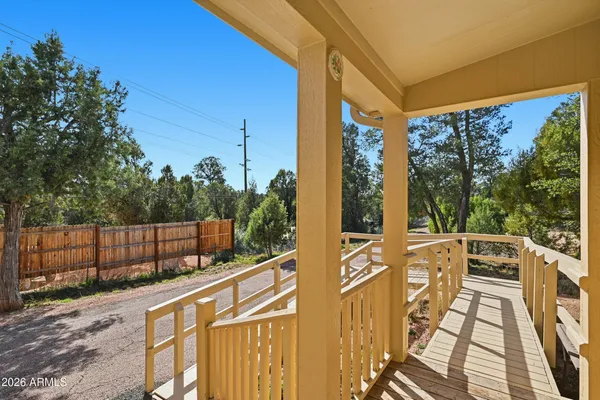 a view of a balcony with chairs and wooden fence