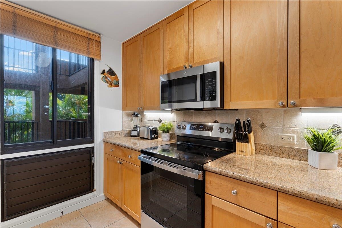 2695 South Kihei Road, Unit 5205 Kihei, HI 96753 - Photo 13 of 43 a kitchen with stainless steel appliances granite countertop a sink a stove and a microwave