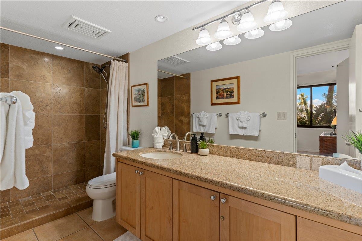 2695 South Kihei Road, Unit 5205 Kihei, HI 96753 - Photo 31 of 43 a bathroom with a granite countertop sink a toilet a mirror and shower