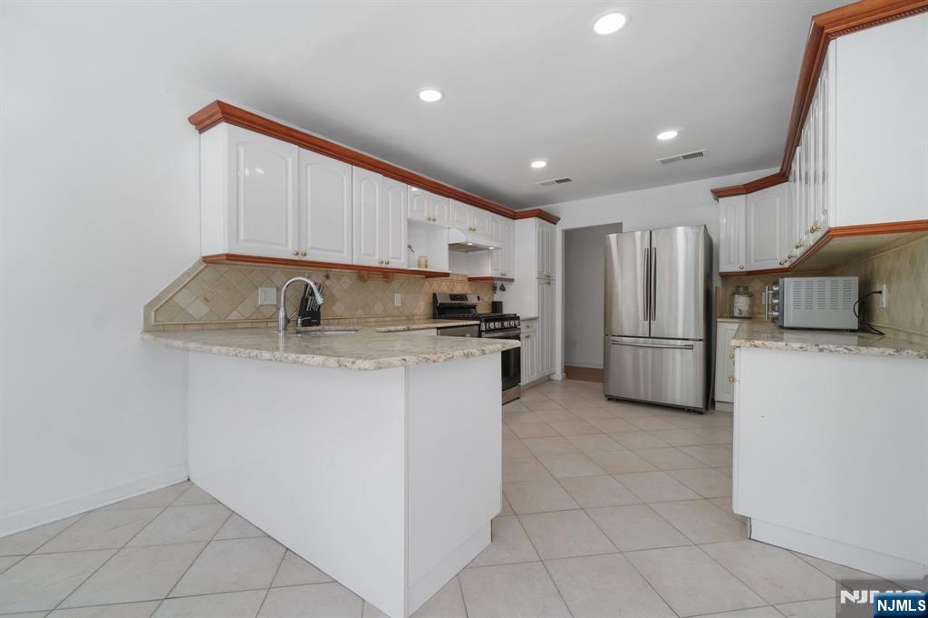 45 Center Street Englewood Cliffs, NJ 07632 - Photo 14 of 18 a kitchen with refrigerator and cabinets