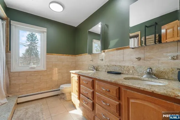 a bathroom with a granite countertop sink a mirror and bathtub