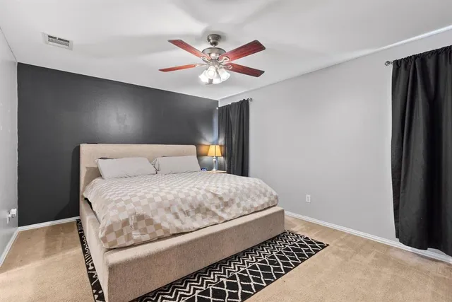 a bedroom with a bed and a ceiling fan