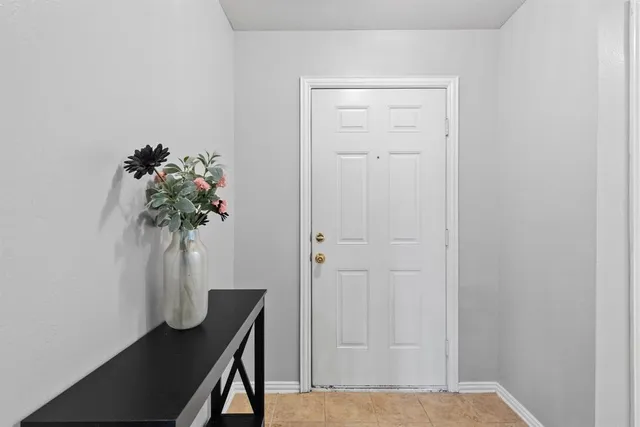 a view of a hallway with flower pot and a table