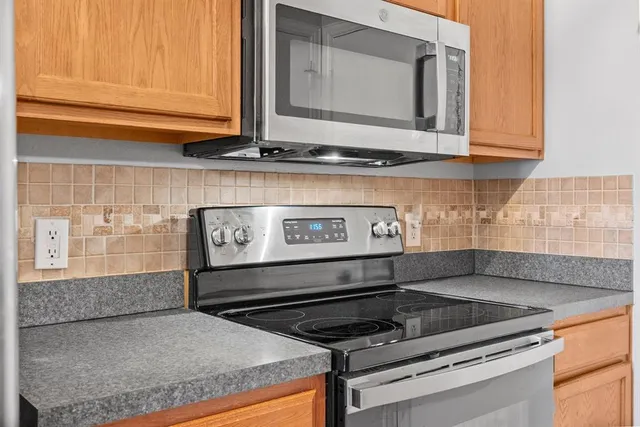 a kitchen with granite countertop a sink a stove and cabinets