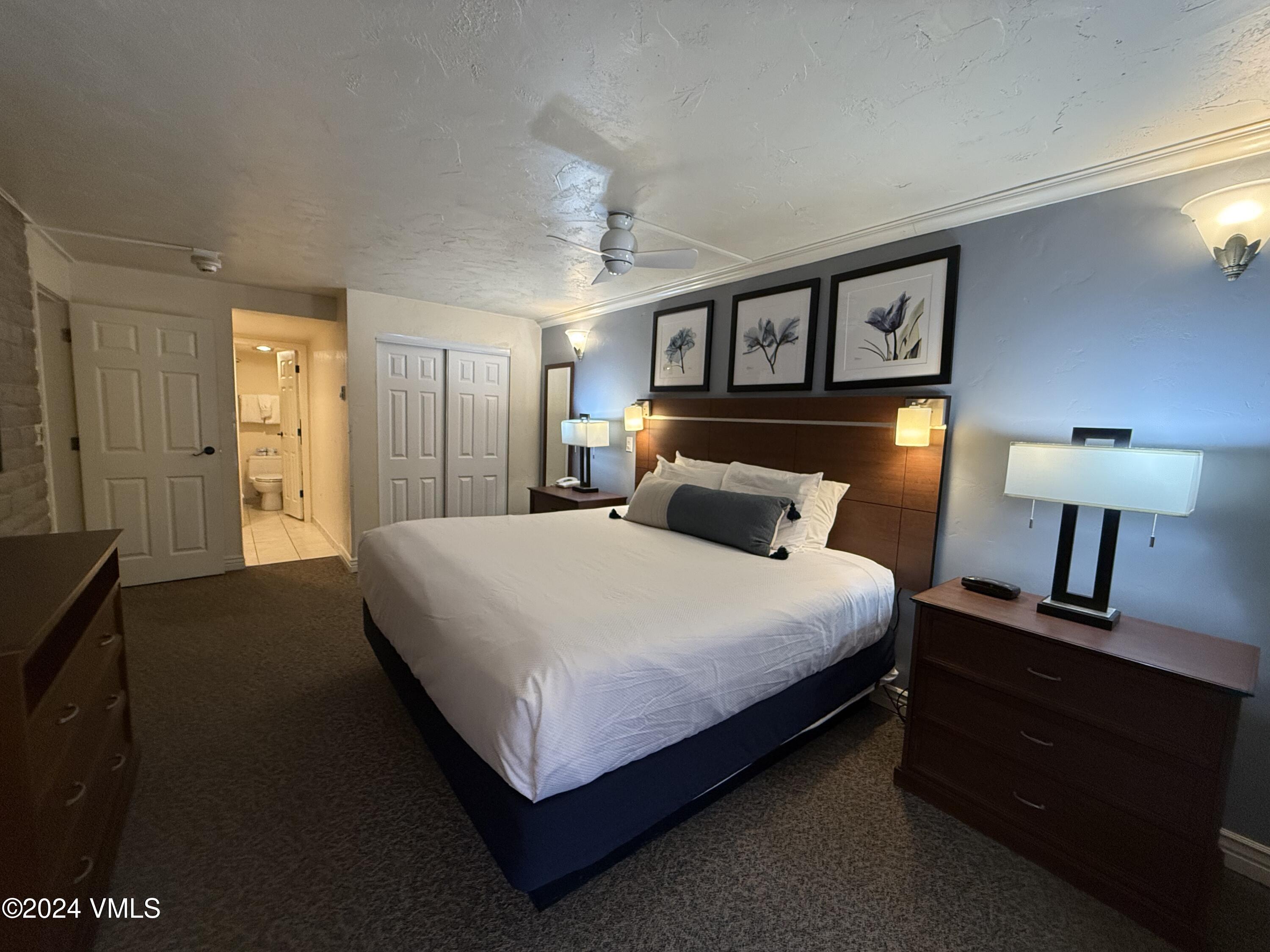 1020 Vail View Drive, Unit 220434 Vail, CO 81657 - Photo 6 of 21 a bedroom with a bed and a lamp on dresser