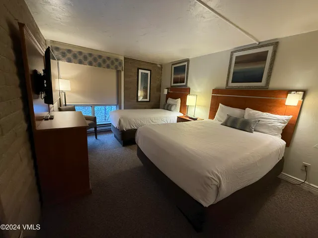a bedroom with a large bed and a flat screen tv