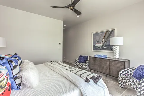 a bedroom with a bed and a lamp on dresser