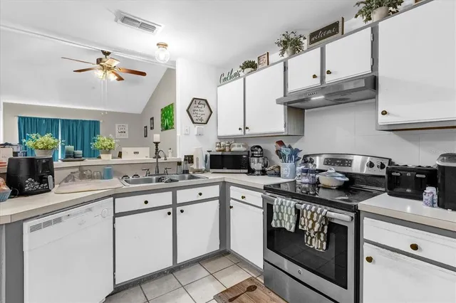 a kitchen with cabinets appliances a sink and a stove