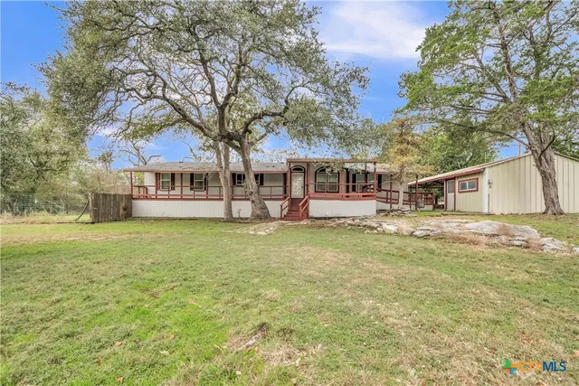 a front view of a house with a garden and tree