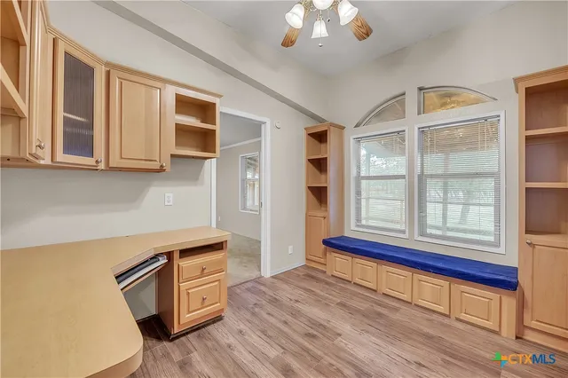a view of a kitchen with wooden floor and cabinets