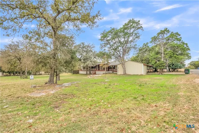 a view of a house with a yard and sitting area