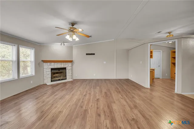 a view of an empty room with a window and fireplace