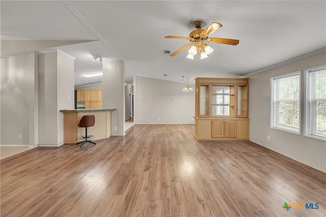 a view of empty room with wooden floor and fireplace