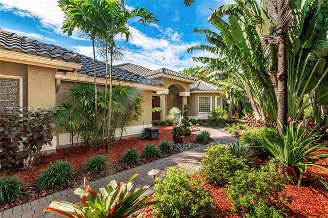 a view of a house with a big yard and potted plants