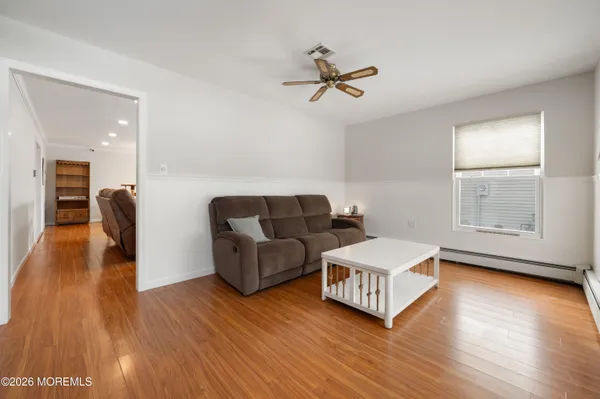 a living room with furniture and a wooden floor