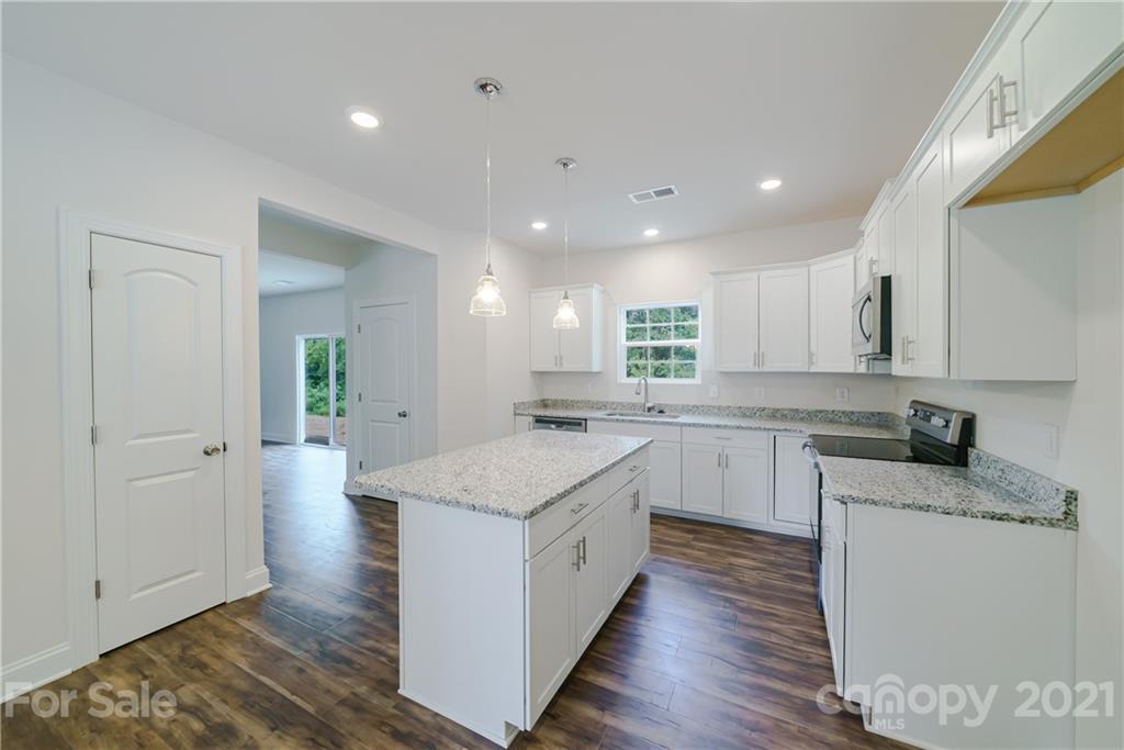 1720 Love Road Monroe, NC 28110 - Photo 7 of 48 a kitchen with white cabinets appliances and wooden floor
