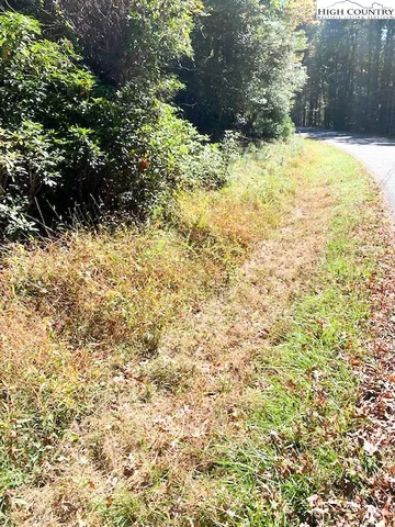 a view of white fence of a house with a yard