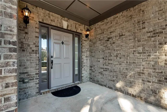 a view of a hallway with wooden floor staircase and a chandelier