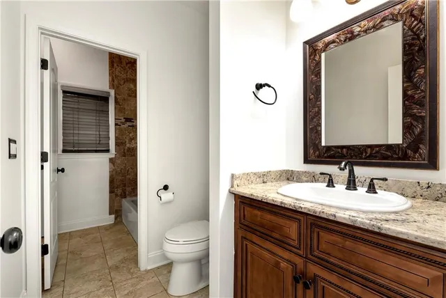 a kitchen with stainless steel appliances granite countertop a refrigerator a sink dishwasher a stove and a dining table with wooden floor