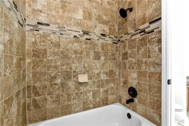 a kitchen with stainless steel appliances granite countertop a refrigerator a stove and a wooden floor