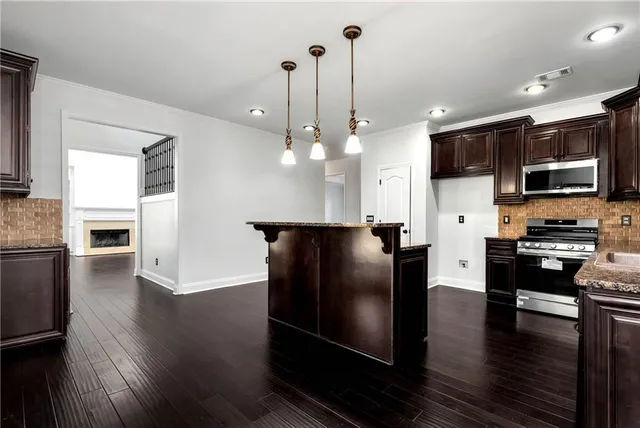 a view of an empty room and chandelier fan