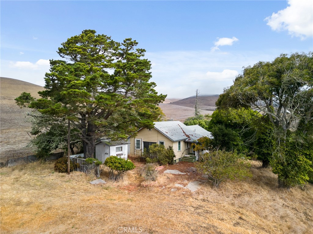 2645 Adobe Road Morro Bay, CA 93442 - Photo 2 of 28 a backyard of a house with table and chairs under an umbrella