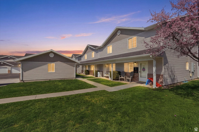 View of front of house with covered porch and a front lawn