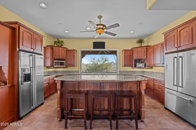 a kitchen with granite countertop a sink a counter top space appliances and cabinets