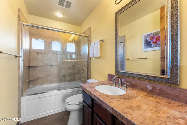 a bathroom with a granite countertop sink toilet and shower