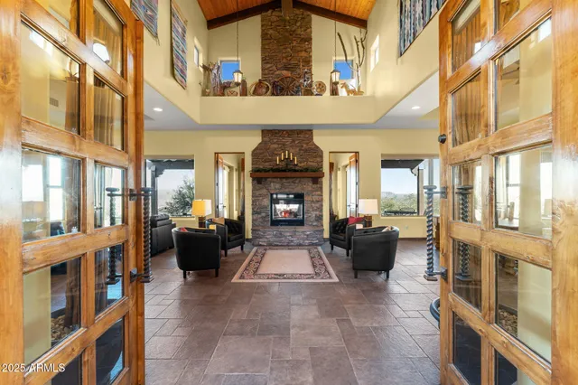 a living room with furniture large windows and a fireplace