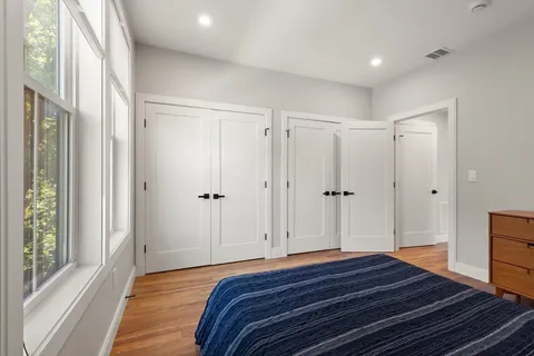 a bedroom with a bed and wooden floor