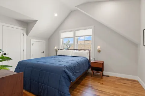 a bedroom with a bed a table and a potted plant