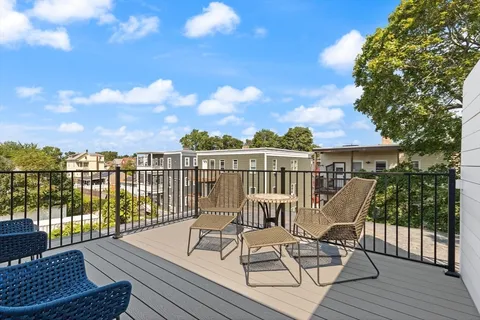 a view of a balcony with wooden floor and outdoor seating