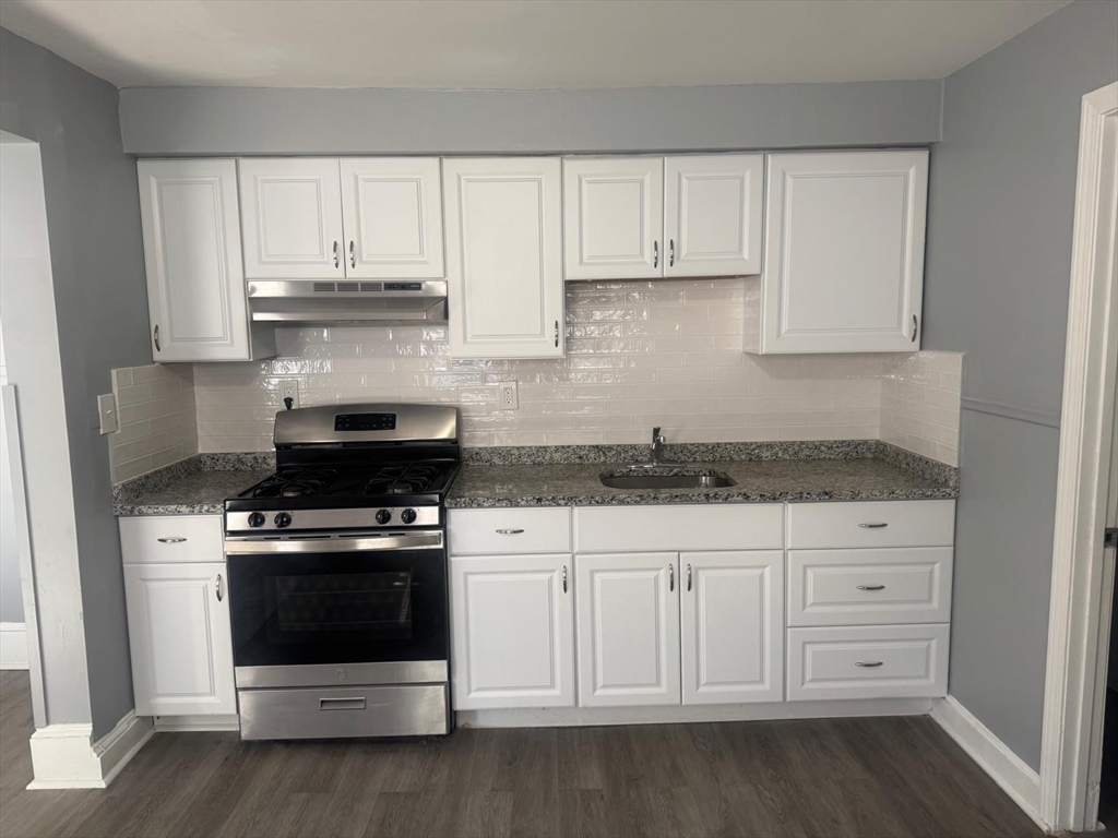 170 Warren Court, Unit 1 Lowell, MA 01852 - Photo 3 of 5 a kitchen with granite countertop white cabinets and stainless steel appliances