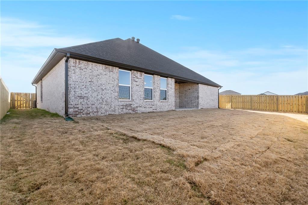 1910 Peacock Road Centerton, AR 72719 - Photo 29 of 29 Enclosed backyard featuring a privacy fence, brick exterior, and a covered patio area