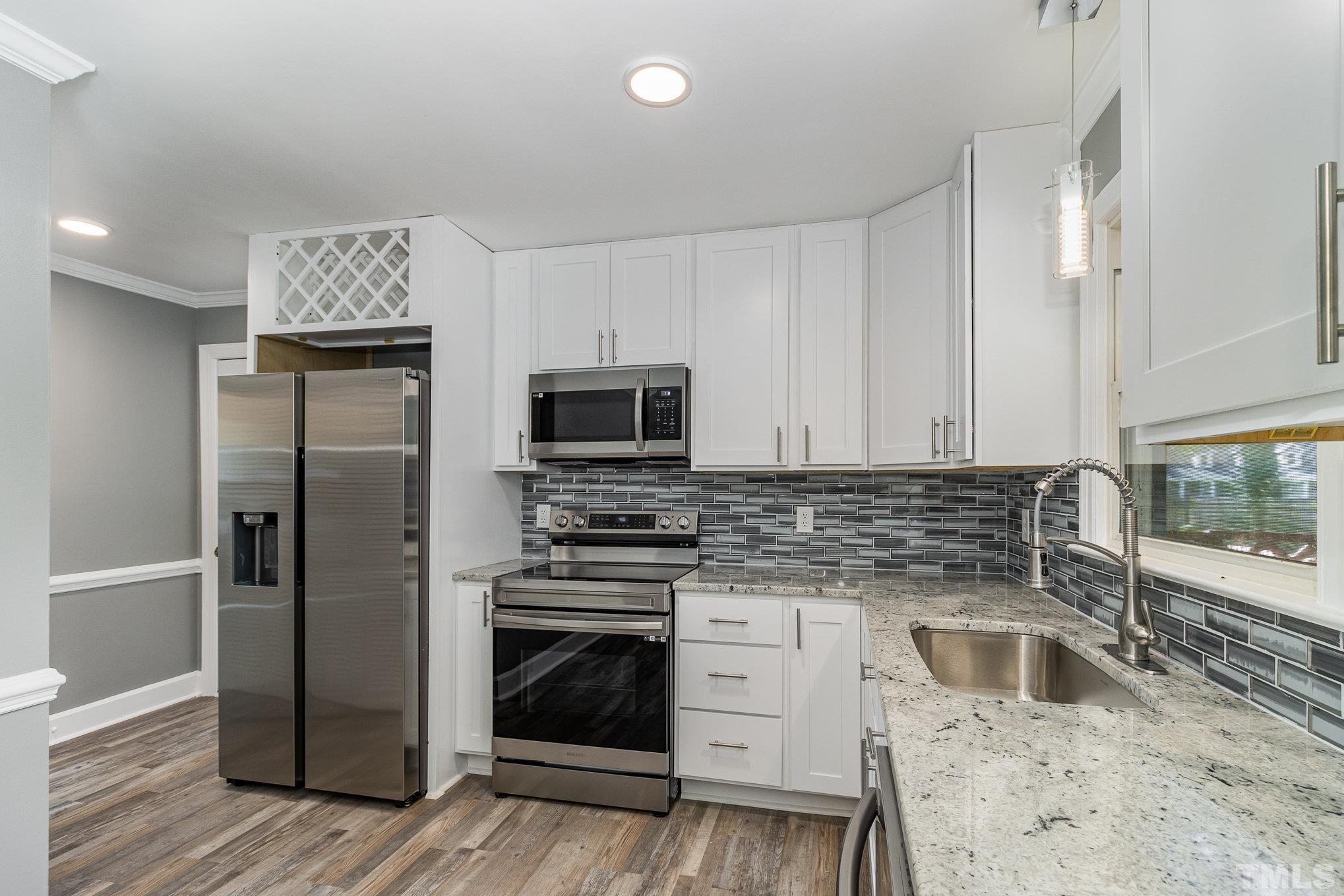 14 Eden Drive Smithfield, NC 27577 - Photo 13 of 37 a kitchen with granite countertop a stove sink and refrigerator