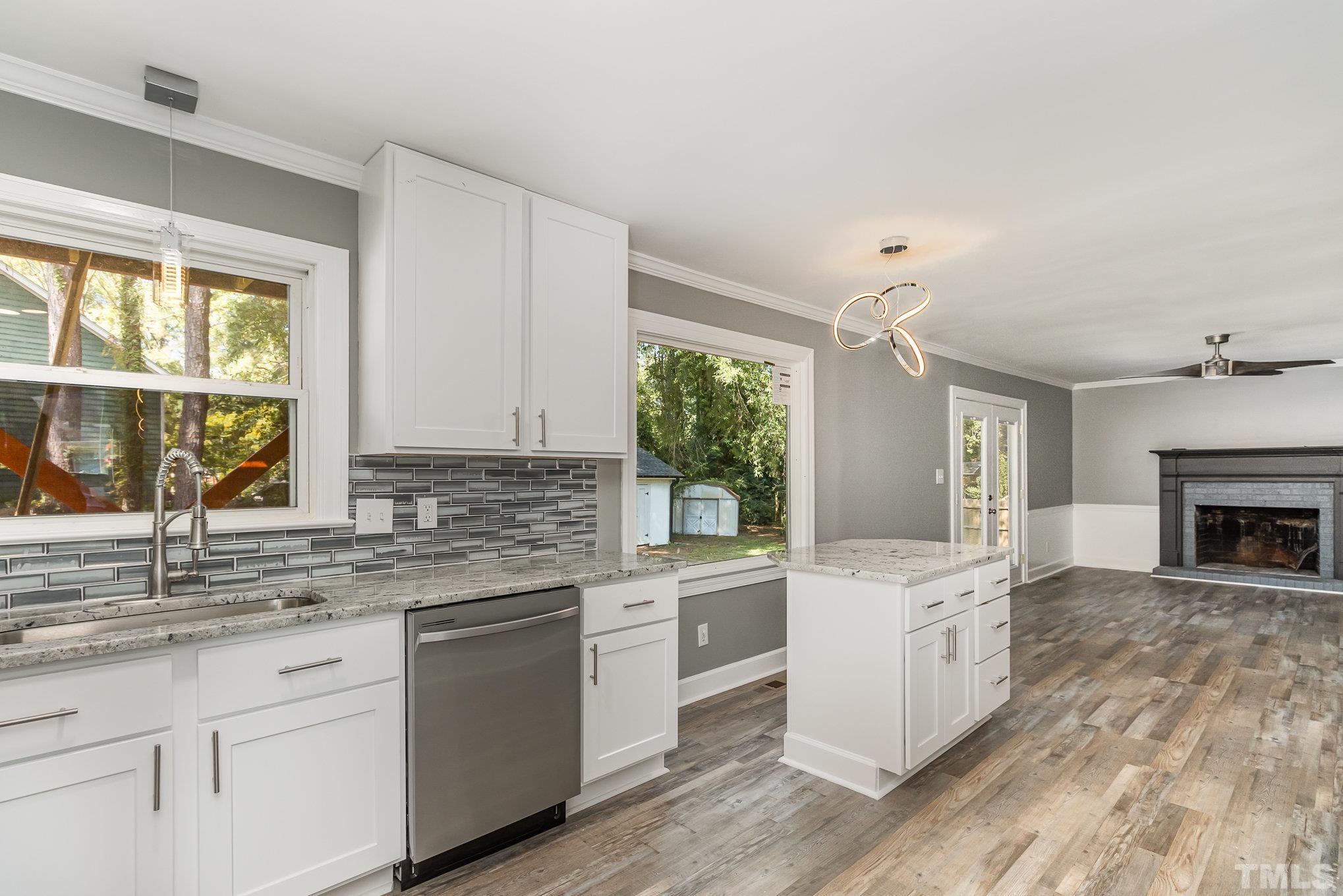 14 Eden Drive Smithfield, NC 27577 - Photo 15 of 37 a kitchen with granite countertop a stove a sink dishwasher and white cabinets with wooden floor